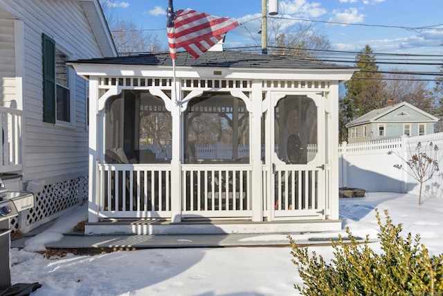 exterior space featuring roof with shingles and fence