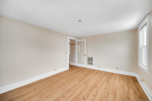 empty room featuring heating unit and light hardwood / wood-style flooring