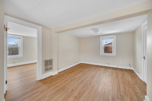 spare room with heating unit and light hardwood / wood-style flooring