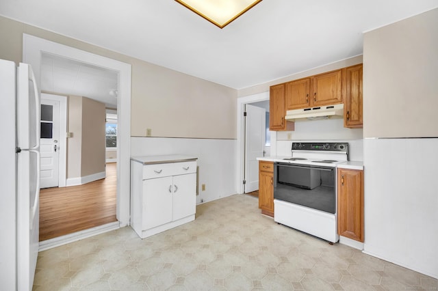 kitchen with electric range oven and white refrigerator