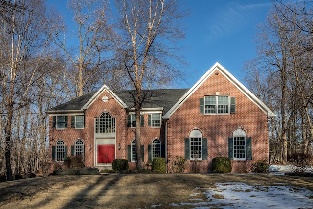 view of front of home with brick siding and a front lawn