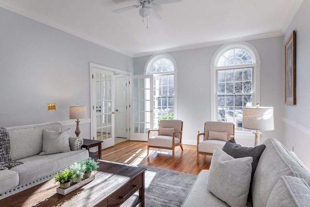 living room with crown molding, a ceiling fan, wood finished floors, and french doors