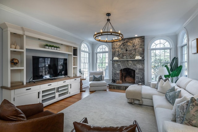 living room featuring plenty of natural light, a fireplace, ornamental molding, and wood finished floors