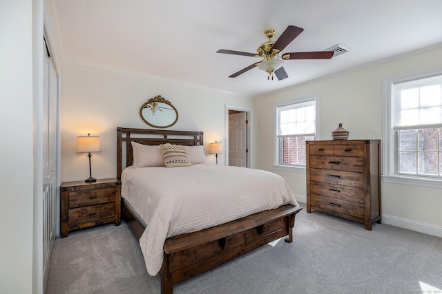 bedroom with light carpet, visible vents, baseboards, a ceiling fan, and ornamental molding