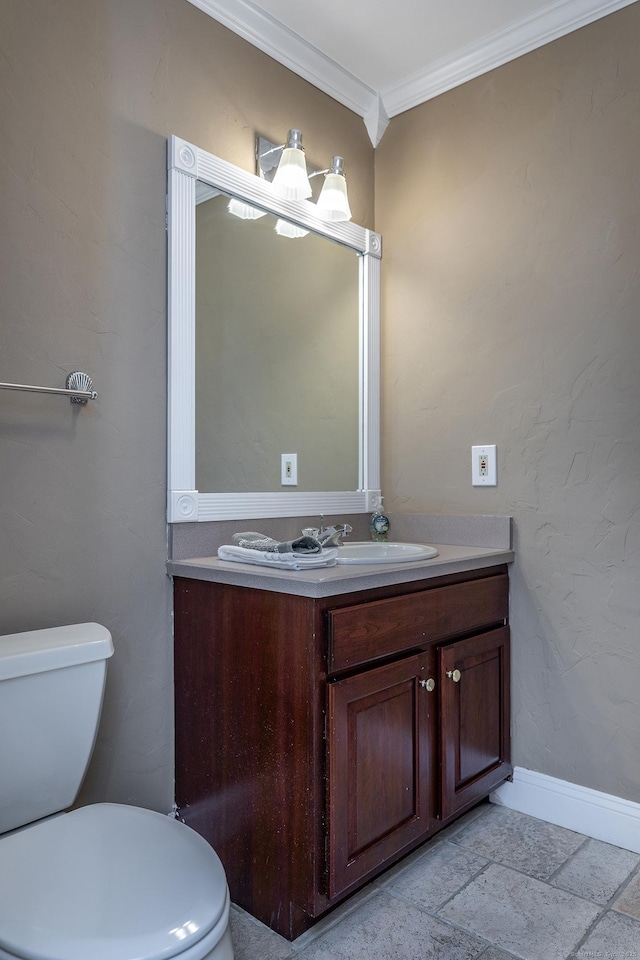 bathroom with toilet, stone tile flooring, vanity, and crown molding