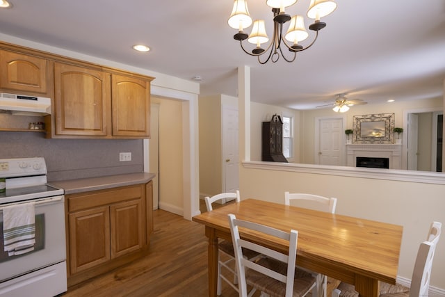 dining room featuring baseboards, recessed lighting, ceiling fan with notable chandelier, a fireplace, and wood finished floors