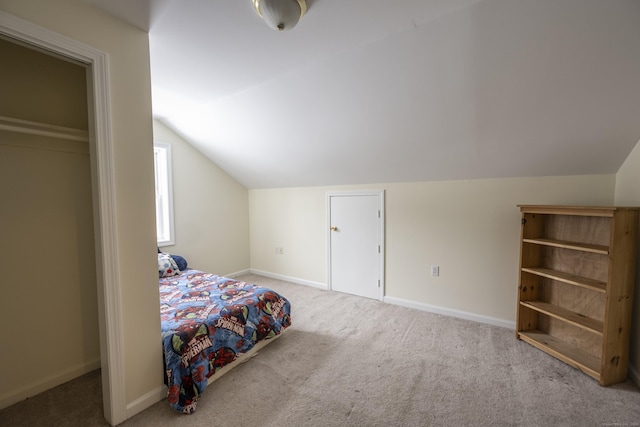 carpeted bedroom featuring baseboards and lofted ceiling