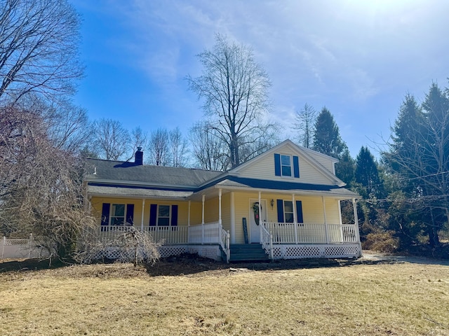 farmhouse featuring a front lawn, covered porch, and a chimney