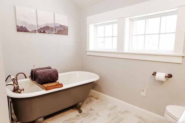 bathroom featuring a tub to relax in and toilet