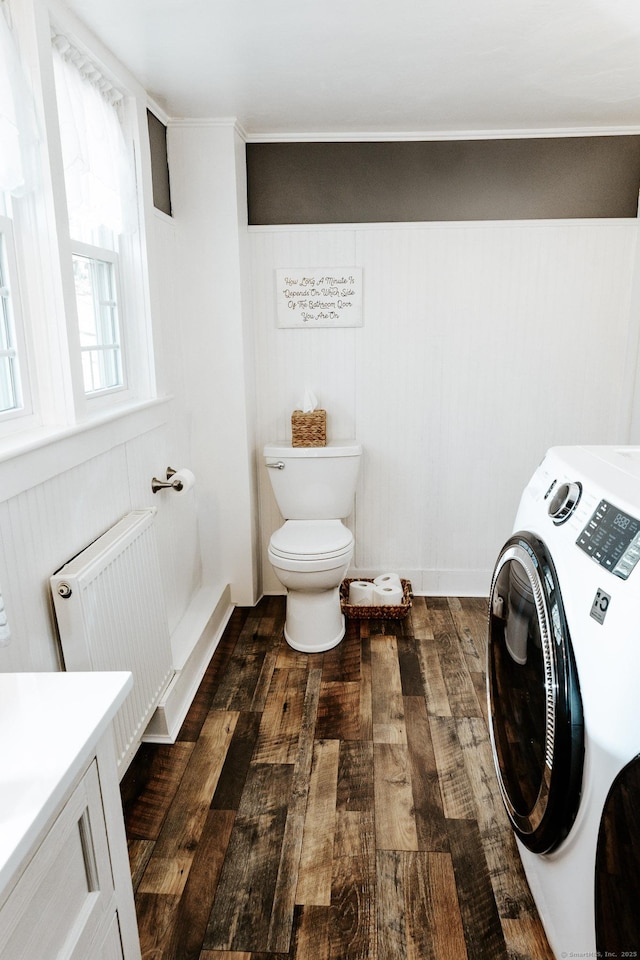 bathroom featuring toilet, washer / dryer, wood-type flooring, radiator heating unit, and vanity