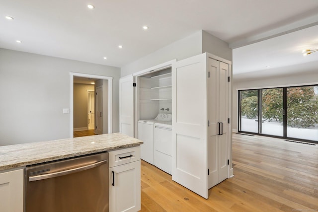 kitchen with dishwasher, white cabinets, independent washer and dryer, light stone counters, and light wood-type flooring