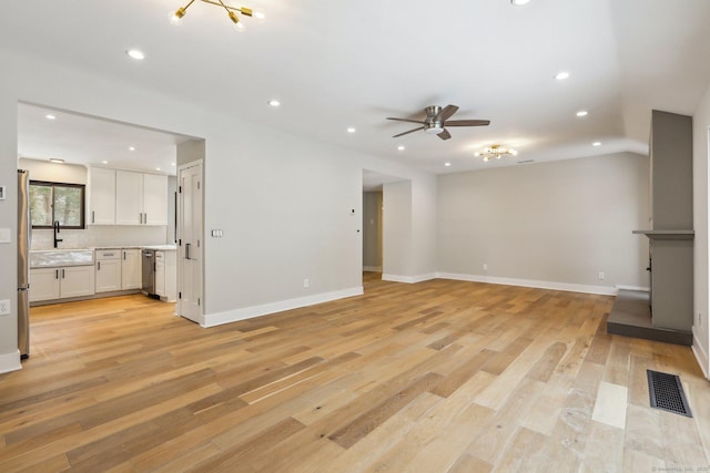 unfurnished living room featuring sink, light hardwood / wood-style flooring, and ceiling fan