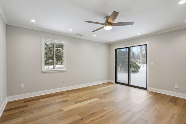 spare room featuring crown molding, a wealth of natural light, ceiling fan, and light hardwood / wood-style flooring