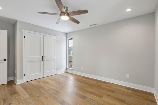 unfurnished bedroom with ceiling fan, light hardwood / wood-style floors, and a closet