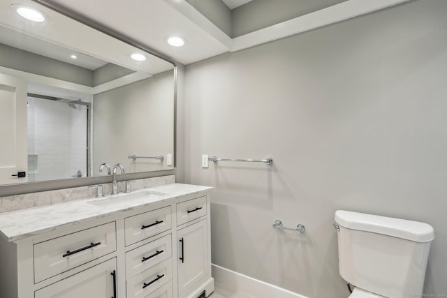 bathroom with recessed lighting, toilet, vanity, and baseboards