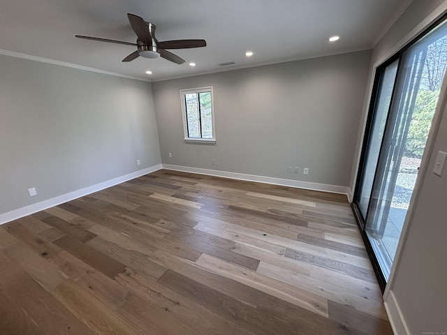 empty room featuring ceiling fan, baseboards, ornamental molding, and wood finished floors