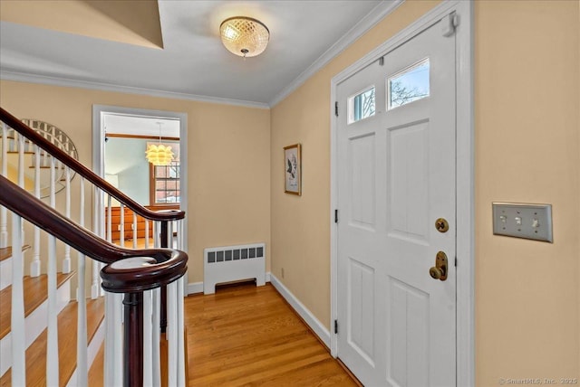 entryway featuring crown molding, radiator heating unit, and light hardwood / wood-style floors