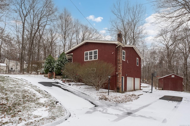 view of snow covered exterior with a garage