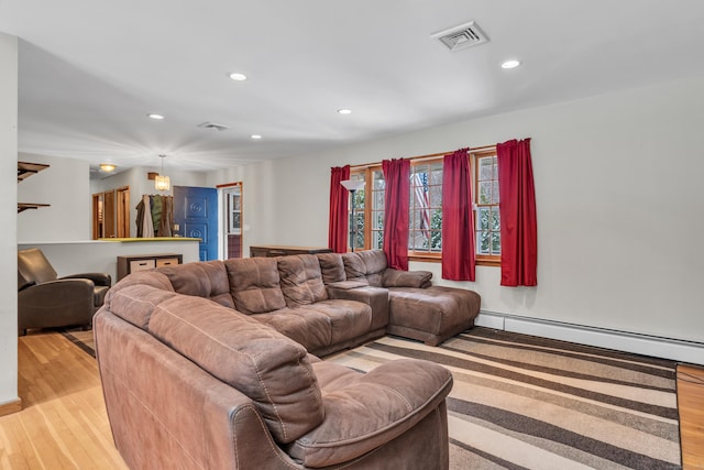 living room featuring a baseboard heating unit and light wood-type flooring