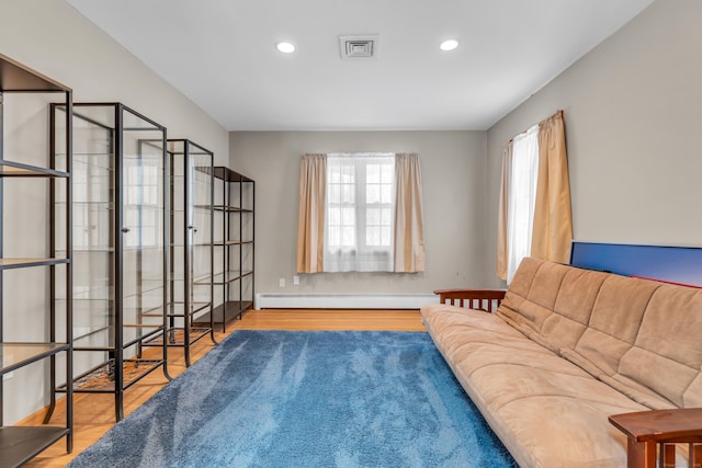 sitting room featuring a baseboard radiator and hardwood / wood-style floors