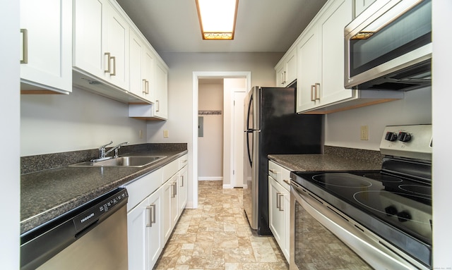 kitchen featuring dark stone countertops, white cabinetry, stainless steel appliances, and sink