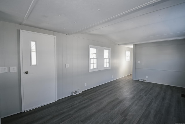 spare room featuring vaulted ceiling and dark hardwood / wood-style floors