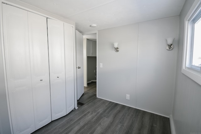 unfurnished bedroom featuring dark hardwood / wood-style flooring and a closet