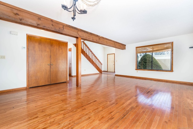 spare room featuring hardwood / wood-style flooring and beamed ceiling