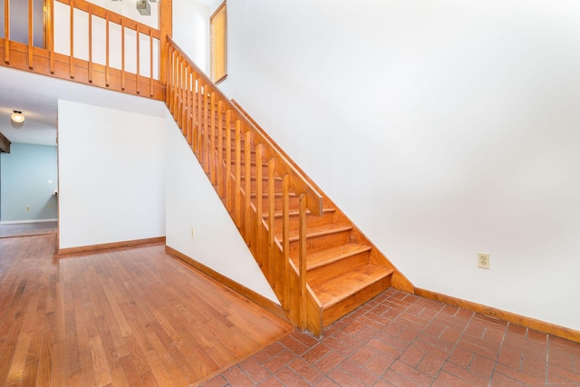 stairway featuring hardwood / wood-style flooring and a high ceiling