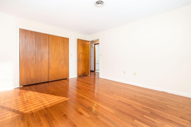 unfurnished bedroom with light hardwood / wood-style floors and a closet