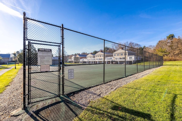 view of sport court with a lawn