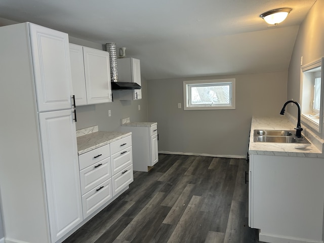 kitchen with vaulted ceiling, light countertops, a sink, and white cabinets