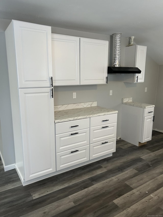 kitchen with wall chimney range hood, baseboards, white cabinetry, and dark wood-type flooring