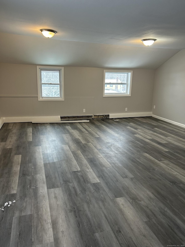 spare room with a healthy amount of sunlight, dark wood finished floors, and baseboard heating