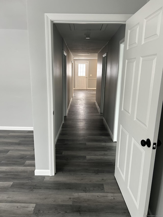 hall featuring attic access, dark wood-style flooring, and baseboards