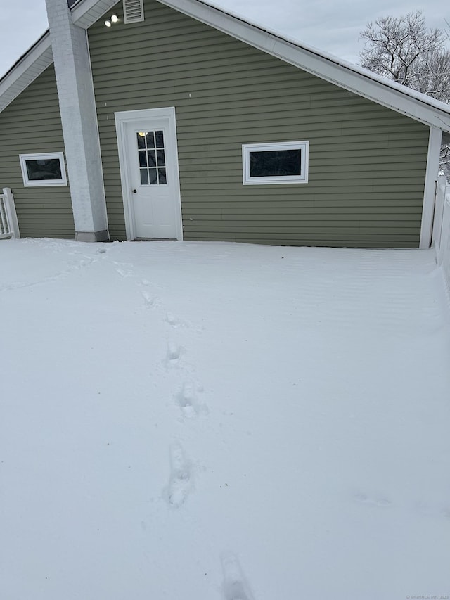 view of snow covered rear of property