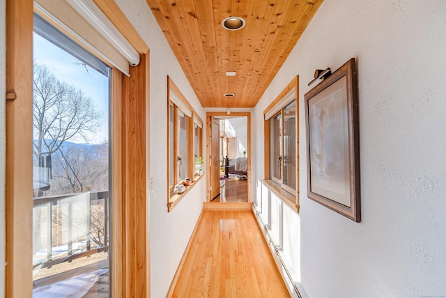 corridor with a mountain view, wood ceiling, and light wood-style floors