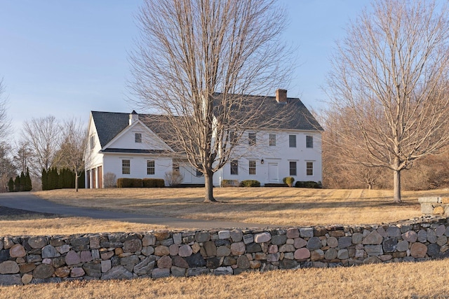 view of front facade with a front yard and a chimney