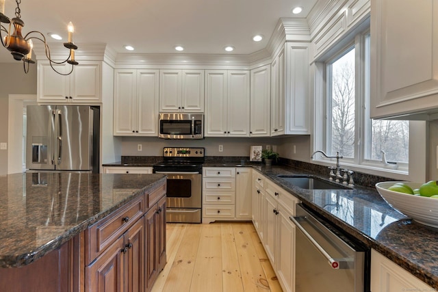 kitchen featuring recessed lighting, stainless steel appliances, light wood-style floors, white cabinetry, and a sink