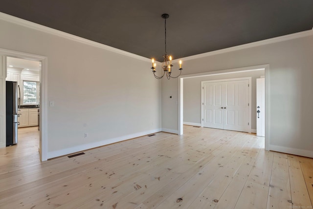 unfurnished dining area with visible vents, crown molding, baseboards, a chandelier, and light wood-type flooring