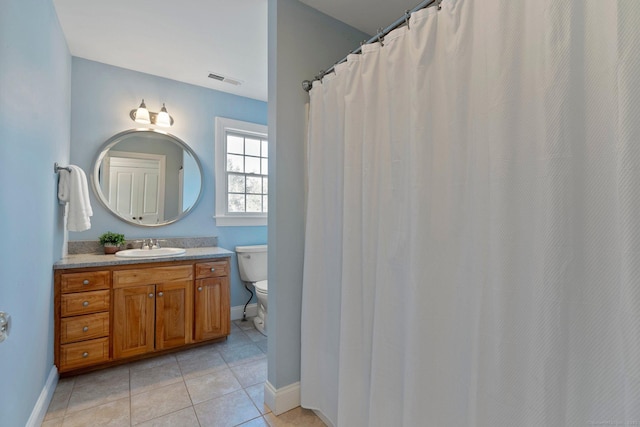 bathroom with vanity, visible vents, baseboards, tile patterned flooring, and toilet