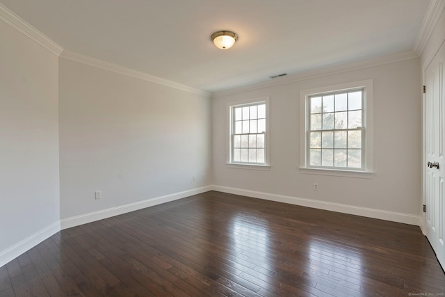 spare room with visible vents, baseboards, dark wood finished floors, and crown molding