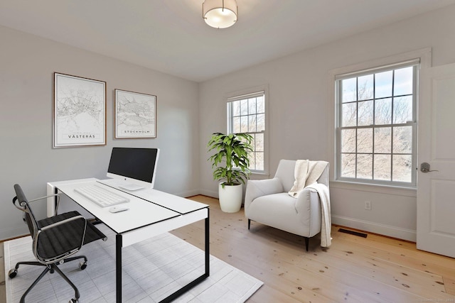 office space featuring visible vents, baseboards, and light wood finished floors