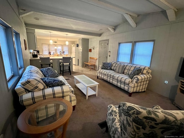 carpeted living room featuring a healthy amount of sunlight and lofted ceiling with beams