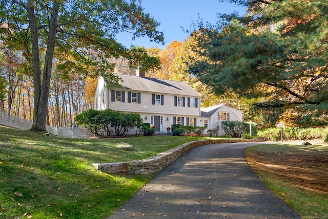 colonial home featuring a front yard