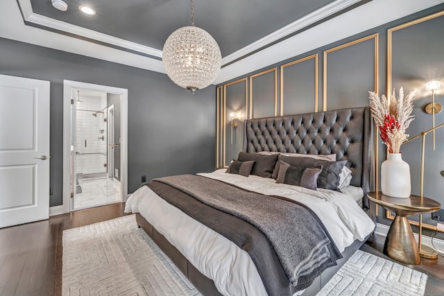 bedroom with a notable chandelier, baseboards, ornamental molding, a tray ceiling, and dark wood finished floors