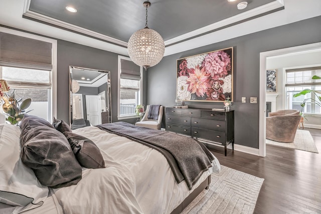 bedroom with multiple windows, ornamental molding, a raised ceiling, and dark wood-style flooring