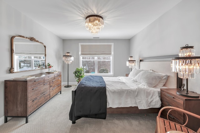 bedroom featuring light carpet, baseboards, and a notable chandelier