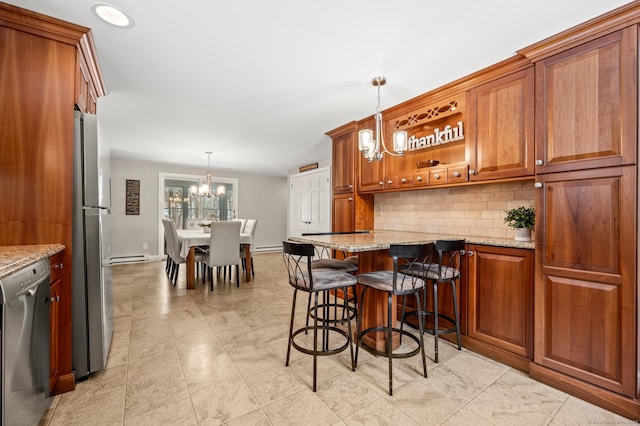 kitchen with appliances with stainless steel finishes, a breakfast bar, pendant lighting, decorative backsplash, and light stone countertops