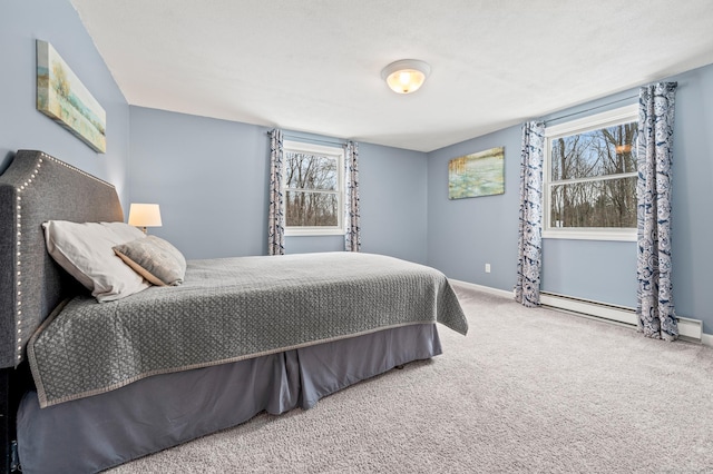 bedroom with baseboard heating and carpet